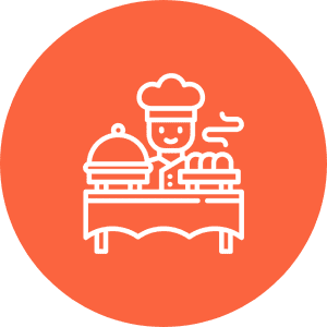 Icon of a smiling chef in uniform, standing behind a table with a covered dish and loaves of bread, against an orange background.