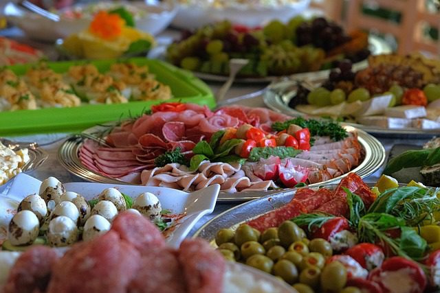 A colorful spread of assorted meats, olives, and cheeses on a buffet table.