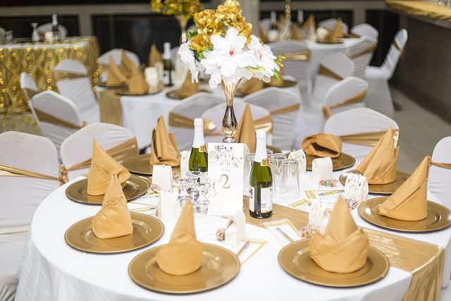 Elegant wedding table setting with gold accents and floral centerpiece.